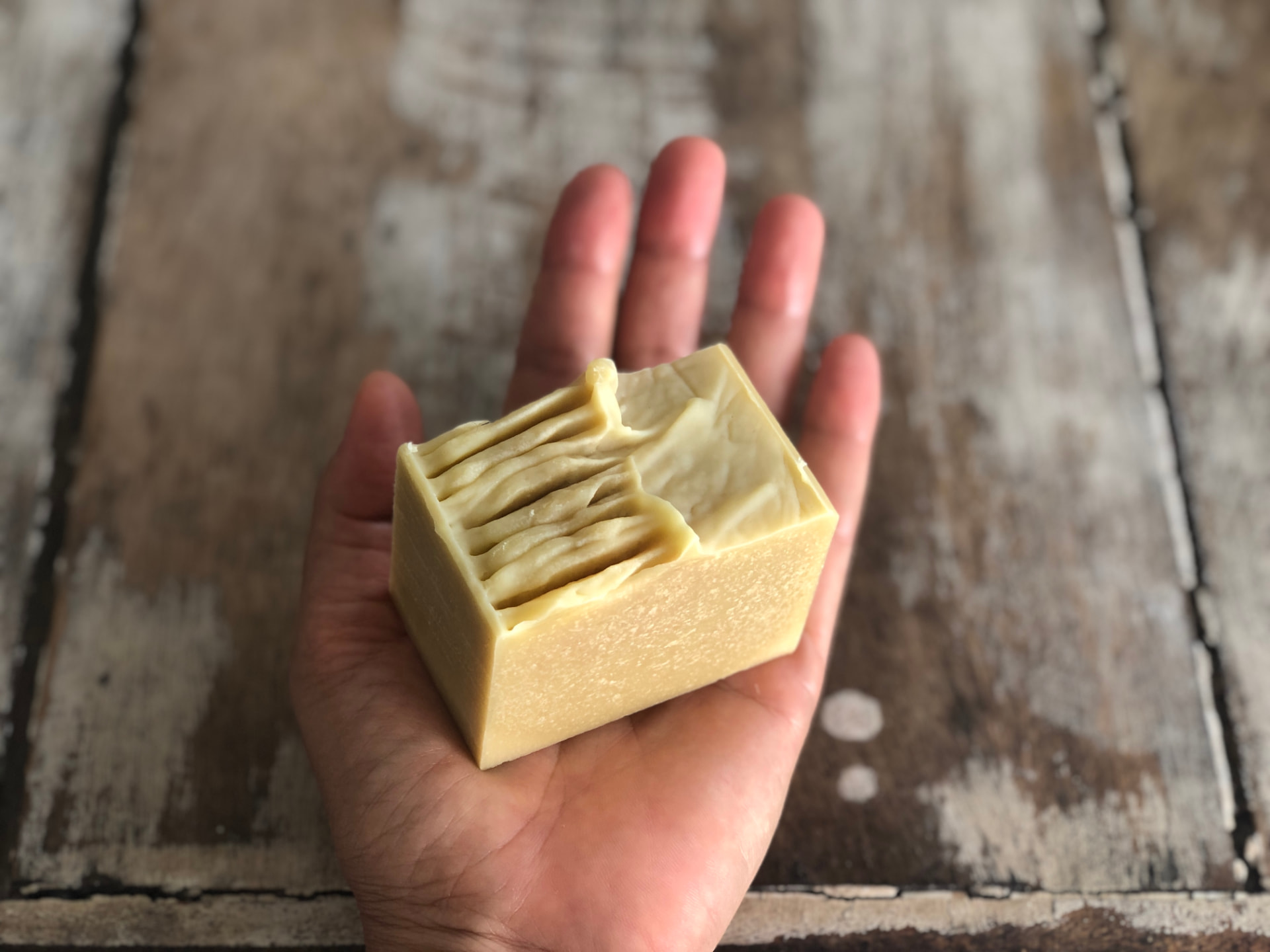 Sabonete artesanal 100% natural com topo ondulado apoiado na palma da mão